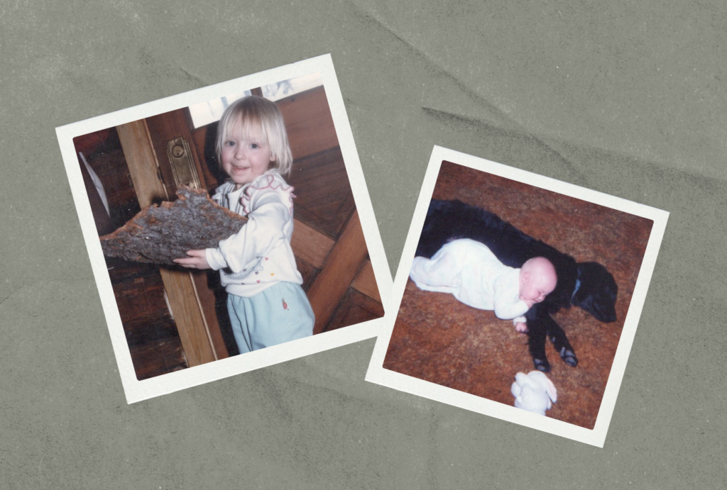 Two vintage snapshots on a gray background. Left: A smiling blond toddler in a white sweatshirt holds a large piece of tree bark inside a wood-paneled cabin. Right: A baby in a white sleeper lies across a sleeping black dog on a brown carpet, with a stuffed white bunny nearby.